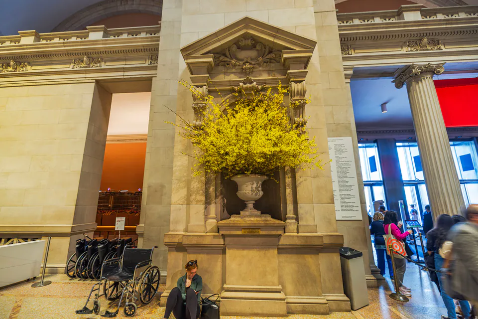 Museum entrance hall with wheelchairs and accessible features near decorative stone alcove