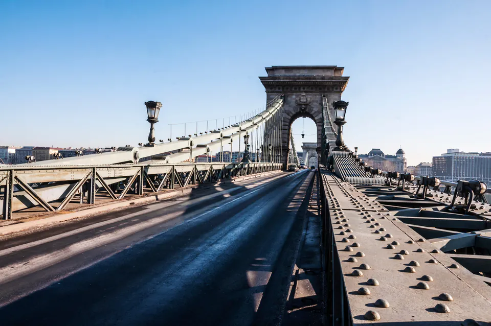 Historic cast-iron lampposts and decorative details along Chain Bridge's roadway and stone tower