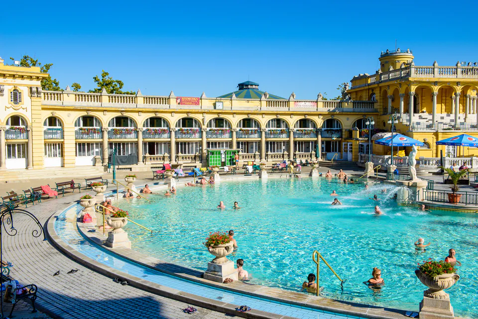 Outdoor pool at Széchenyi Baths with yellow neo-baroque architecture and bathers enjoying thermal waters