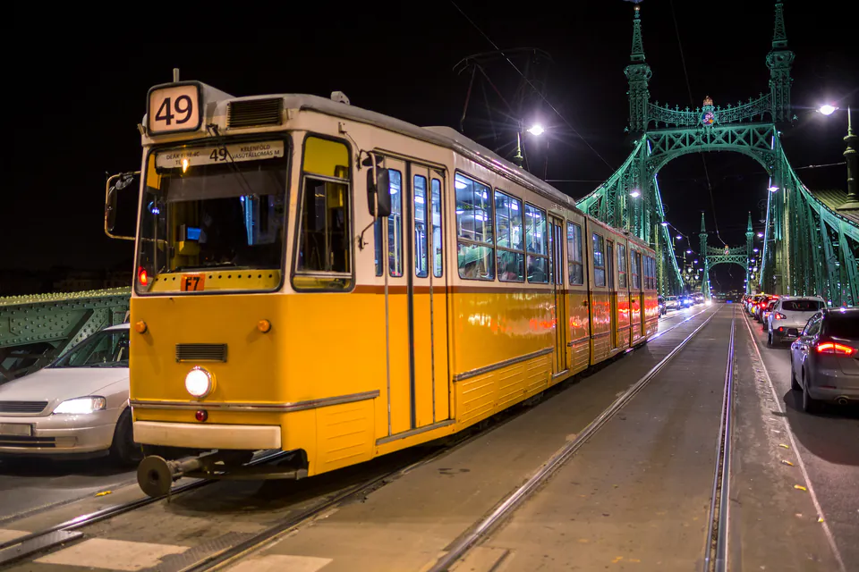 Budapest tram illuminated at night crossing the Grand Boulevard