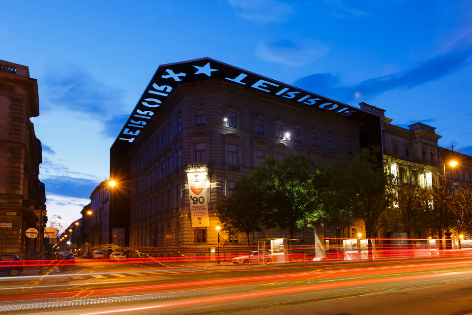House of Terror Museum illuminated at night with distinctive rooftop signage along Andrássy Avenue