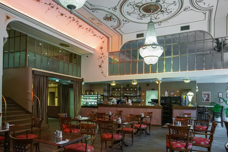 Traditional Hungarian restaurant interior with ornate ceiling, crystal chandeliers and classic wooden furniture