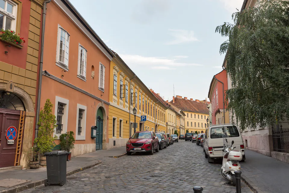 Quiet cobblestone street lined with colorful historic buildings in Budapest's Castle District