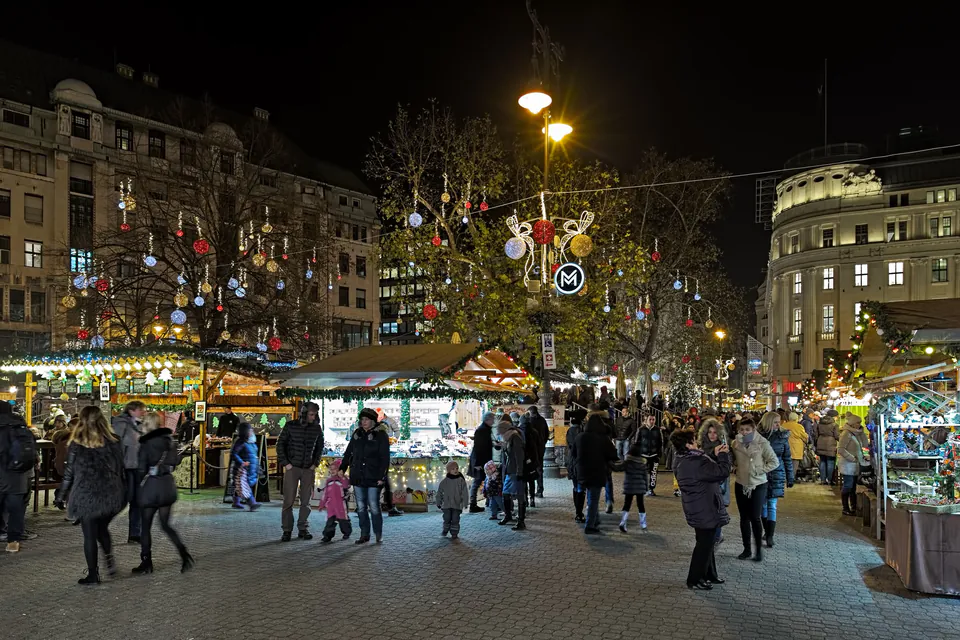 Illuminated Christmas market stalls and decorations at night in Budapest city square