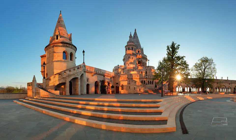 Stone towers and terraces of Fisherman's Bastion illuminated by warm sunrise light