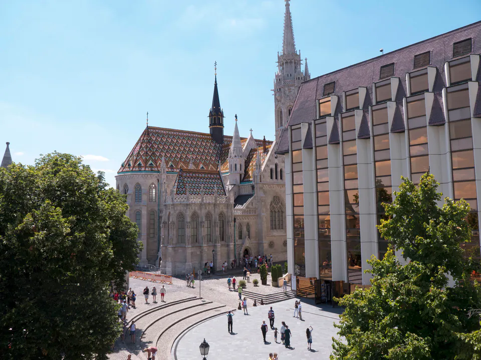 Hilton Budapest hotel's modern facade next to historic Matthias Church in Castle District.