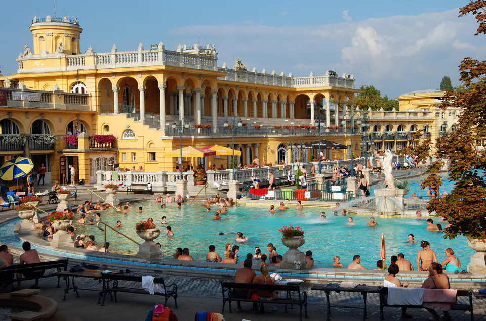 Outdoor thermal pool at Széchenyi Baths with yellow Neo-baroque architecture in background