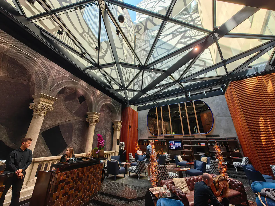 Luxurious hotel lobby with glass dome ceiling, marble floors and elegant classical architecture