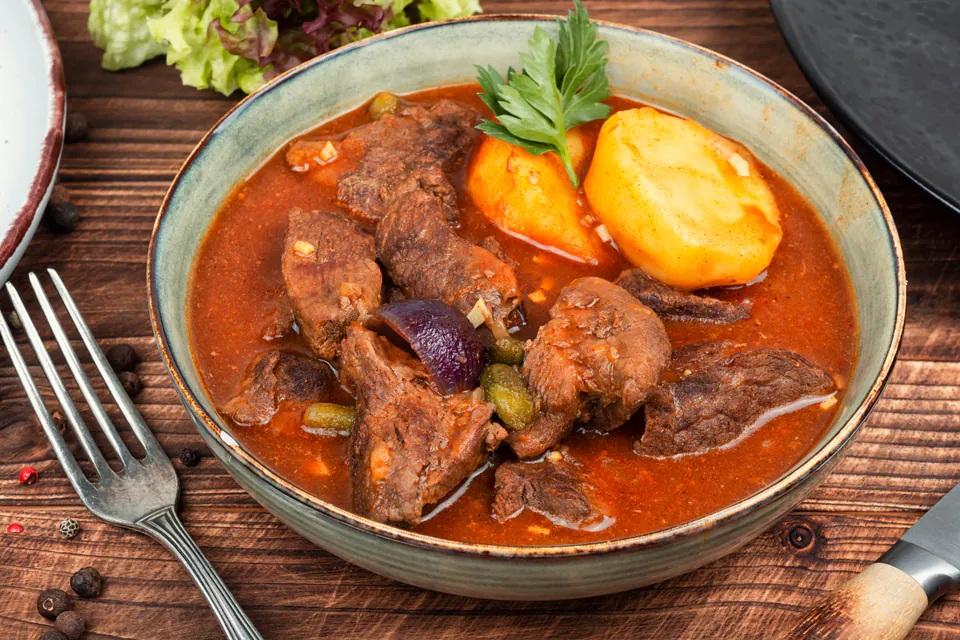 Bowl of traditional Hungarian goulash with tender meat, potatoes, and red paprika broth