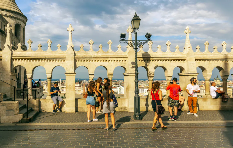 Tourists gathered along the ornate stone balustrade of Fisherman's Bastion viewing terrace