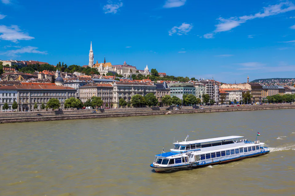 Sightseeing boat cruising along the Danube River with Budapest's historic Buda Castle district in background