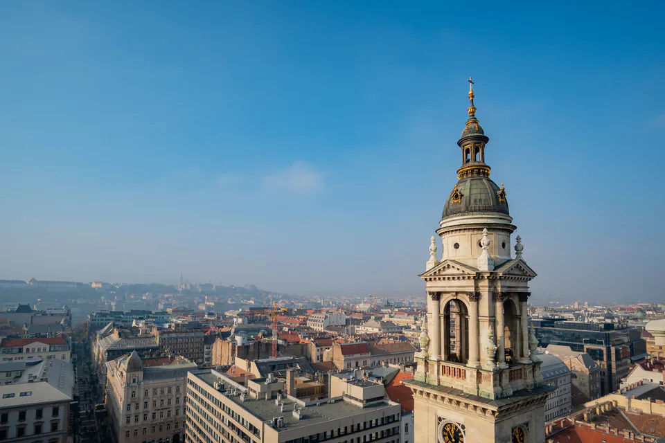 Elevated view of Budapest cityscape with St. Stephen's Basilica tower in foreground, clear sky