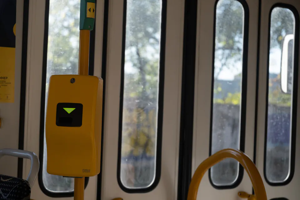 Budapest metro station with orange ticket validation machines and passengers