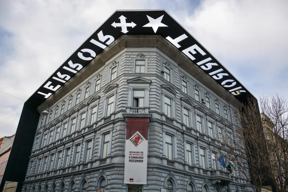 Neo-renaissance building with distinctive black angular frame on top displaying text
