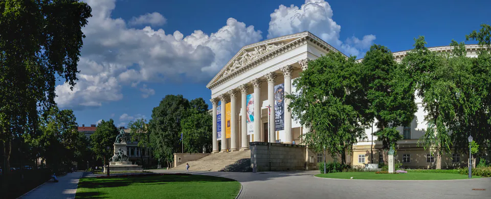 Museum garden with landscaped flowerbeds and green lawns in front of historic building