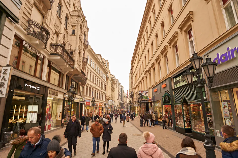 Pedestrian street lined with retail stores and historic buildings in Budapest's shopping district