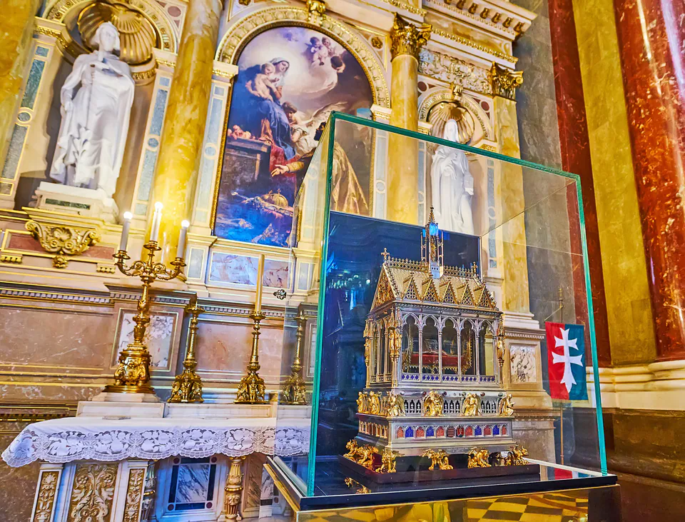 Ornate neo-Gothic reliquary case displaying sacred relic within gilded church interior