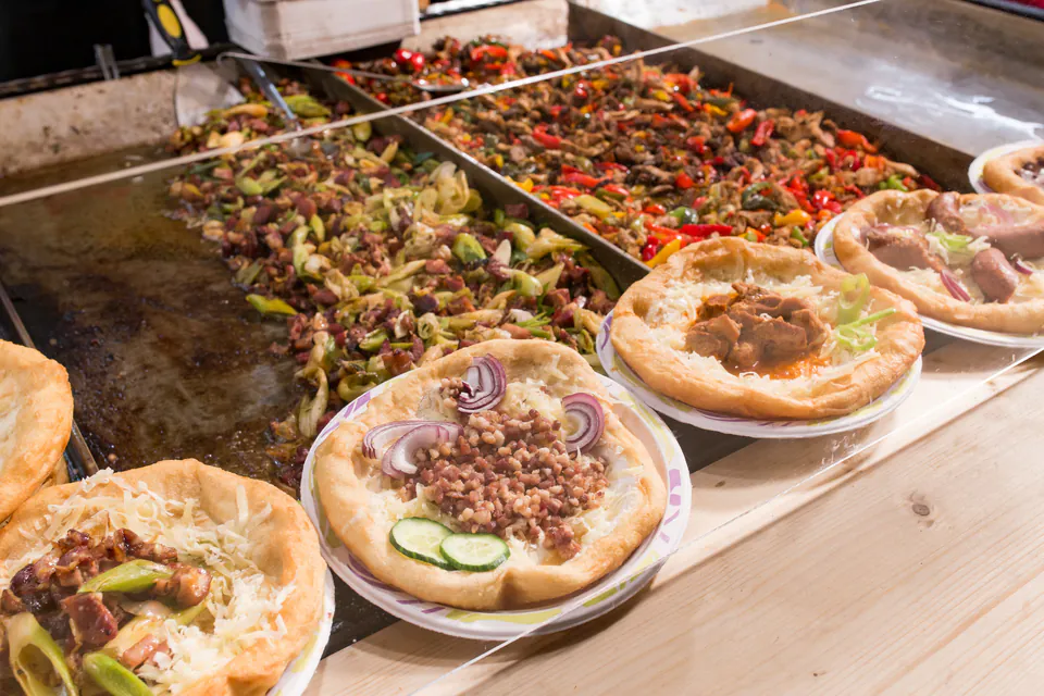 Traditional Hungarian street food dishes being prepared at market food stall