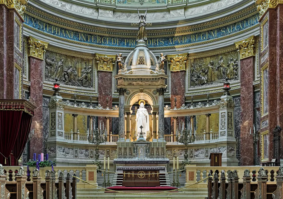 Ornate altar and sanctuary with marble columns, gilded details, and religious sculptures in basilica interior