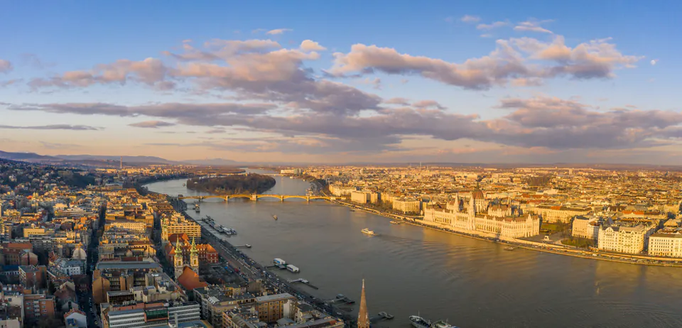 Aerial view of Budapest at golden hour showing Danube River, Parliament building and city panorama