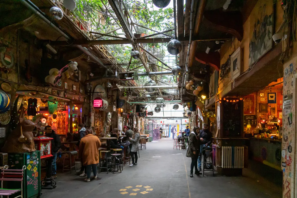 Interior corridor of Szimpla Kert showing eclectic decor, string lights, and bar areas