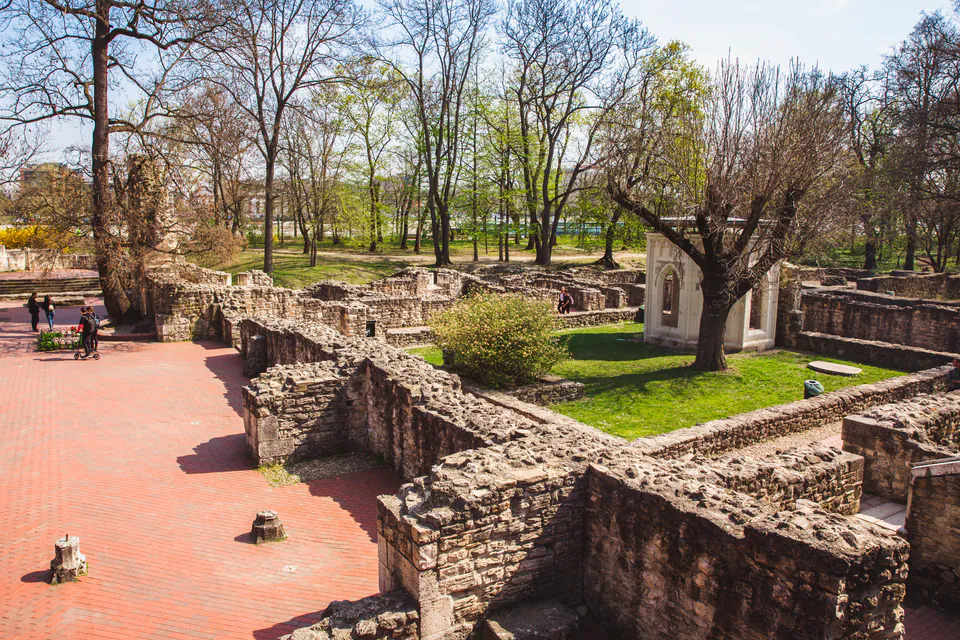 Ancient stone ruins of Dominican convent with walkways and spring trees on Margaret Island