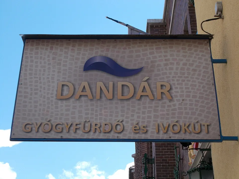 Exterior sign for Dandár thermal baths with Hungarian text against blue sky