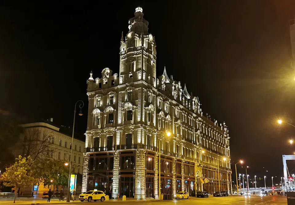 Ornate historic building illuminated at night with Belle Époque architectural details and decorative lighting