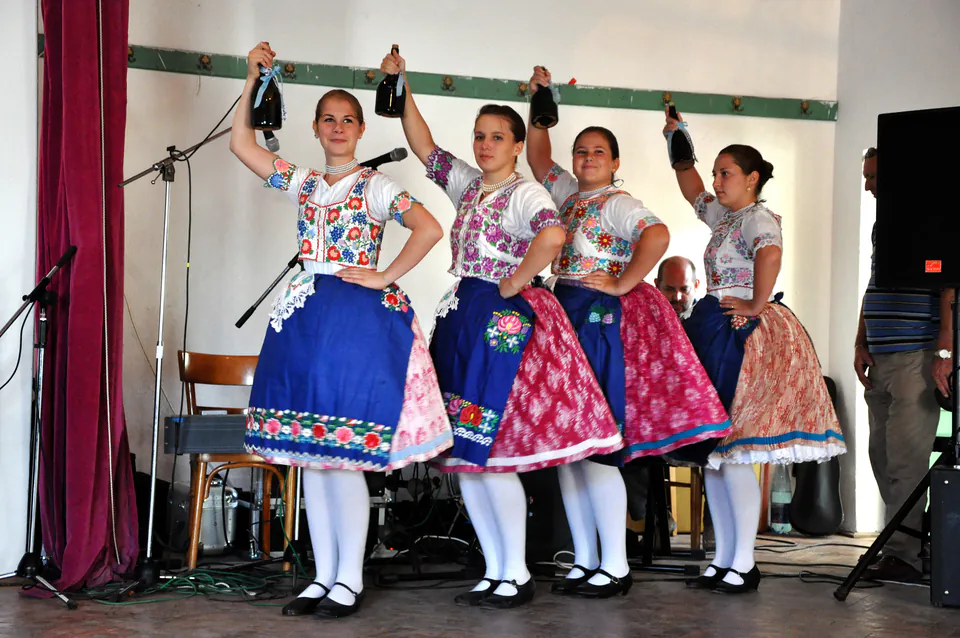 Performers in traditional Hungarian folk costumes dancing on a stage during a river cruise show
