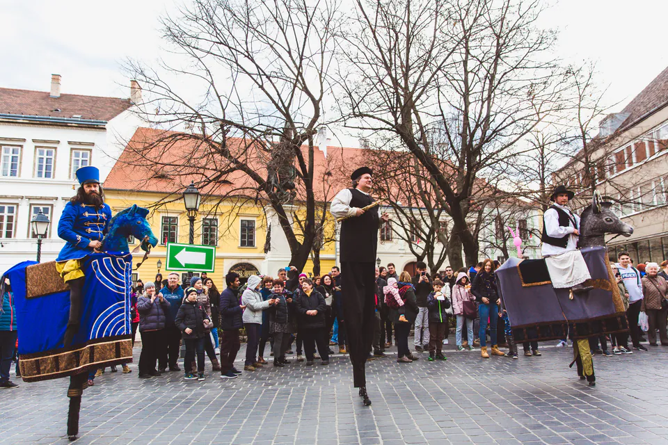 Street performers in traditional costumes entertaining a crowd in a Budapest square