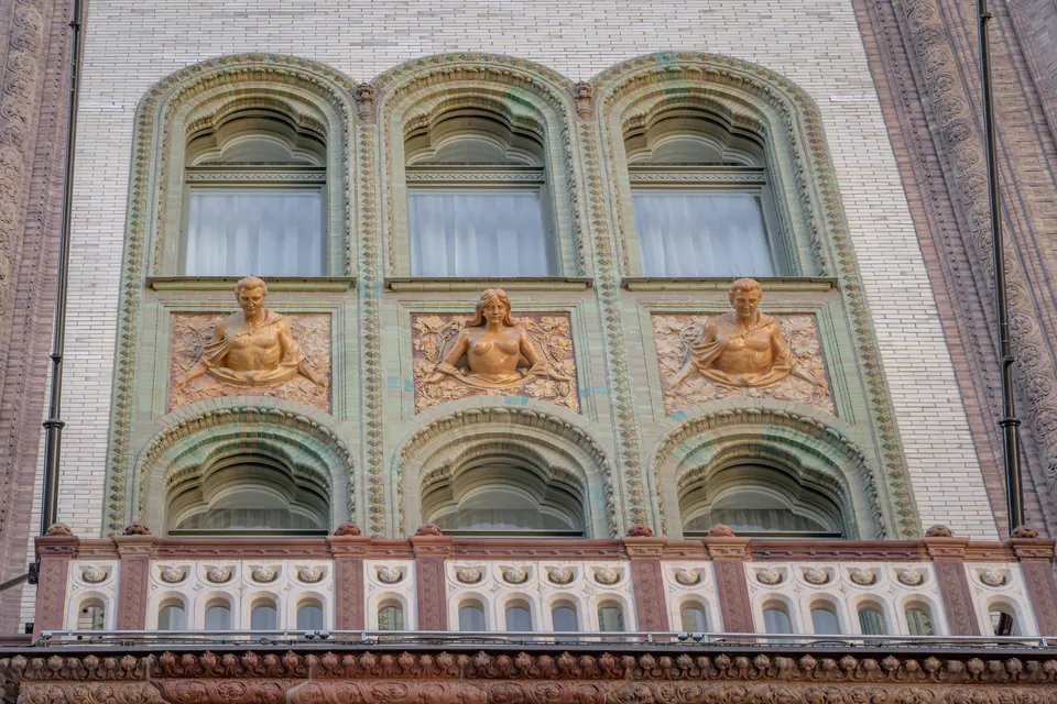 Ornate Art Nouveau building facade with decorative arched windows and sculptural reliefs