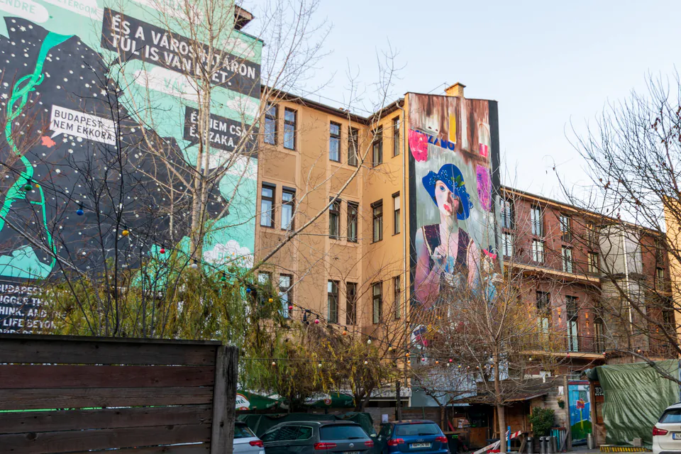 Large colorful murals painted on building walls in Budapest's Jewish Quarter