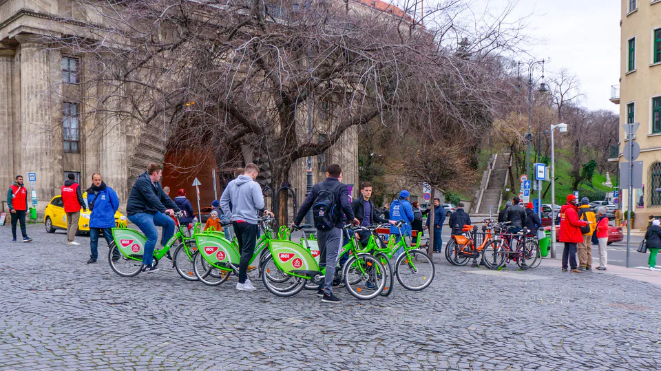Tour group gathering with rental bikes while guide provides orientation in historic square