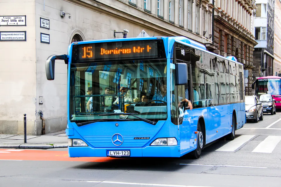 Modern blue Budapest bus at a city stop with digital display showing route information