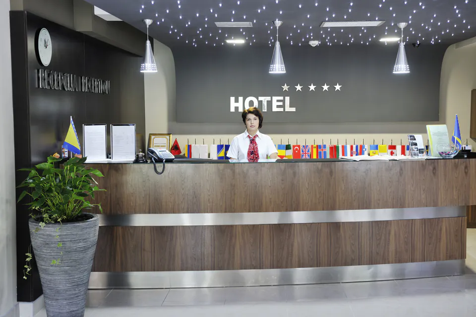 Modern hotel reception desk with decorative ceiling lights and wooden finishes