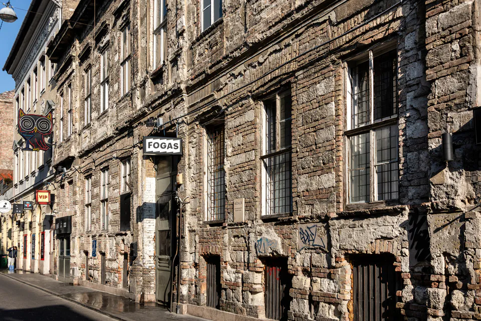 Weathered stone facade of Fogas building with vintage signage in Budapest's Jewish Quarter
