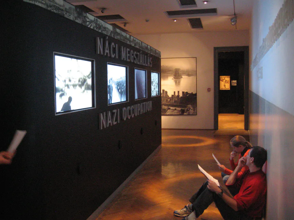 Wide museum corridor with accessible walkways and exhibits about Nazi occupation on display walls