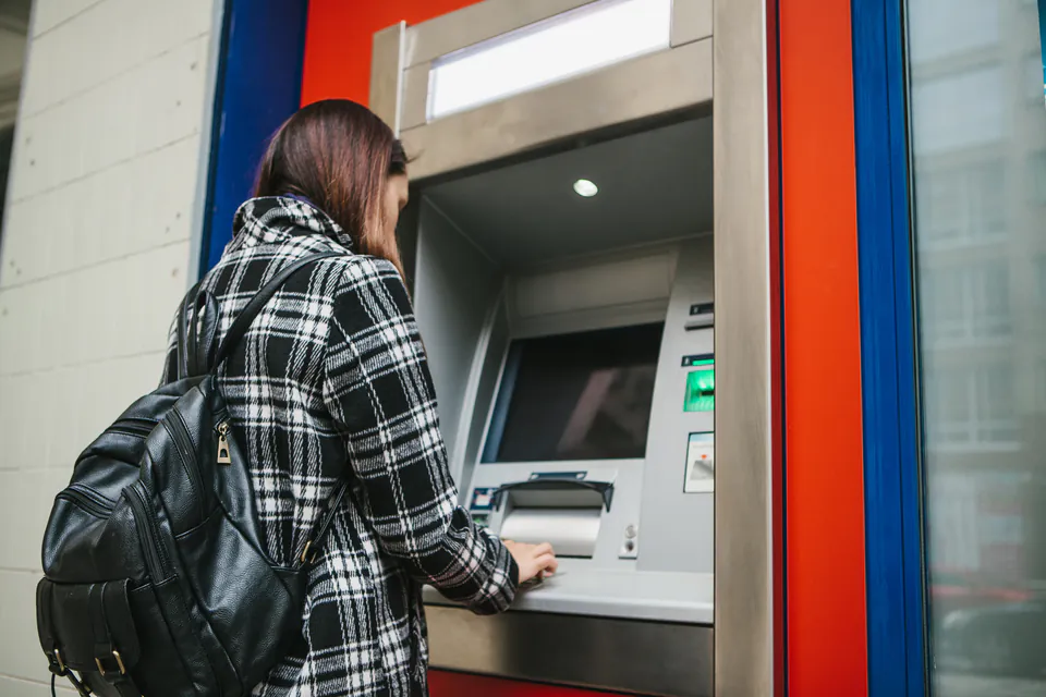 Tourist using ATM in Budapest with proper security awareness