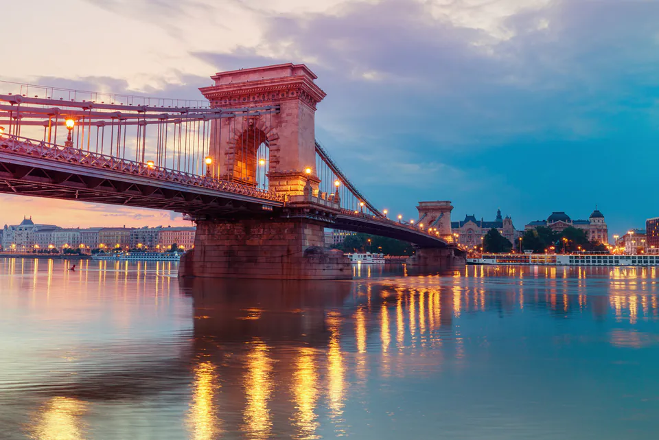 Chain Bridge illuminated at dusk with reflections on the Danube River