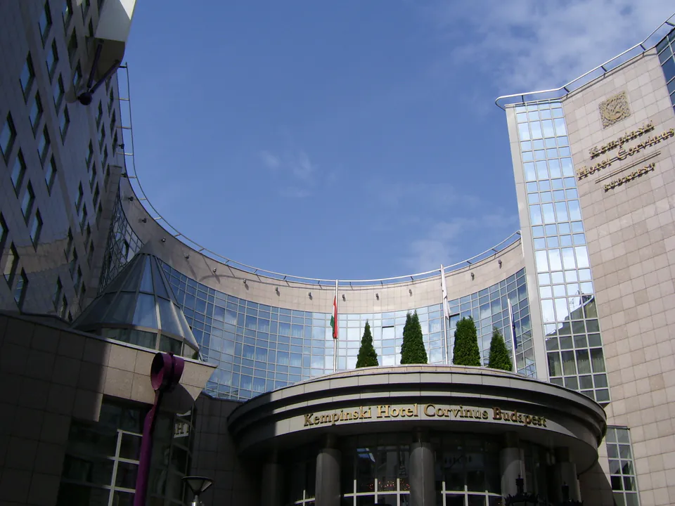 Modern curved facade and entrance of Kempinski Hotel Corvinus with glass windows and columns