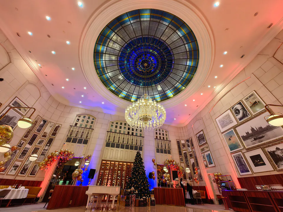 Grand hotel lobby with stained glass dome ceiling, crystal chandelier and elegant marble walls