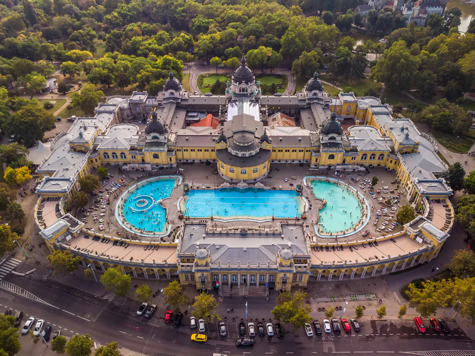 Aerial view of Széchenyi Bath's grand neo-baroque complex with three outdoor pools and surrounding gardens