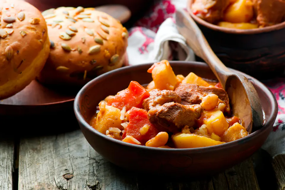 Traditional Jewish-Hungarian cholent stew served in rustic ceramic bowl with meat and potatoes