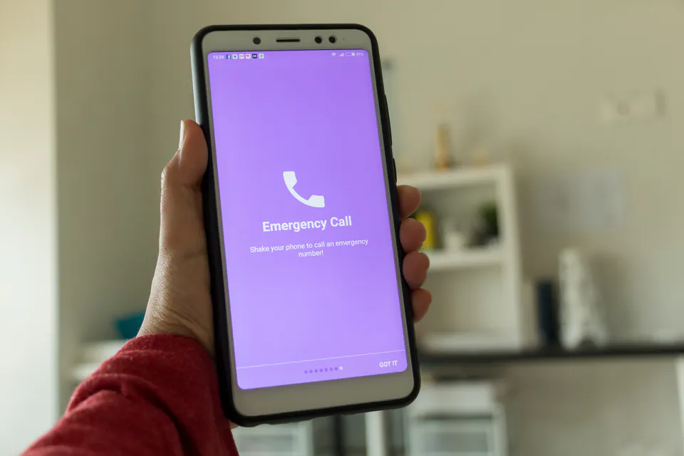 Person dialing emergency number 112 on mobile phone