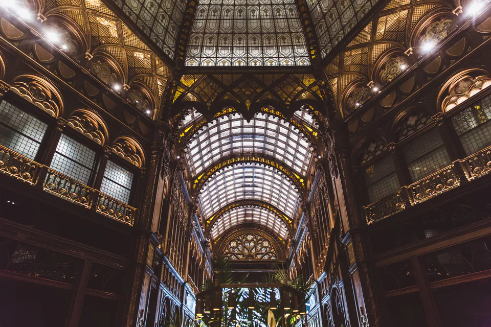 Ornate glass ceiling and architectural details inside a historic Budapest arcade or passage