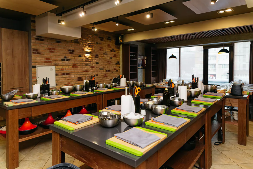 Professional cooking school kitchen with individual workstations set up with cutting boards and tools