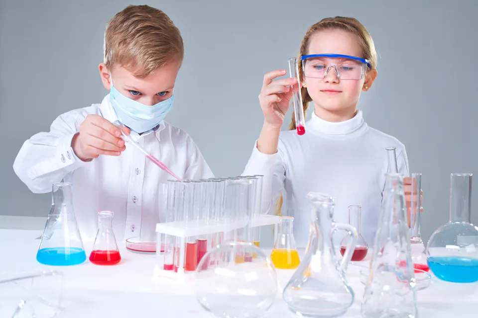 Children in lab coats conducting science experiments at Palace of Wonders