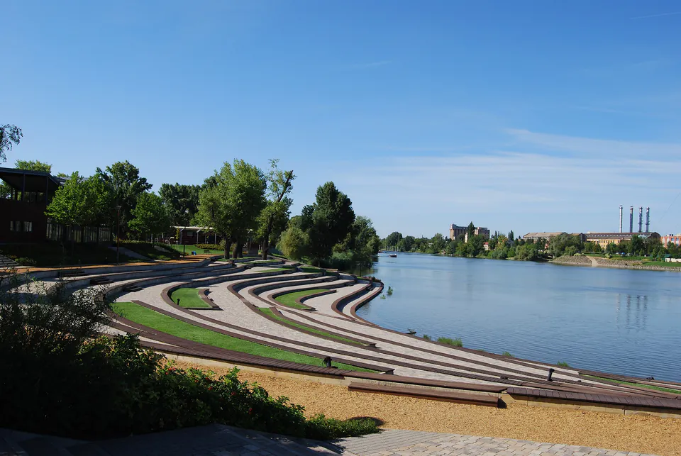 Terraced waterfront promenade with curved steps leading down to the Danube River