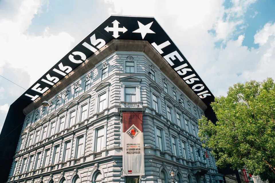 Historic building with black frame entrance displaying 'Terror House' text against blue sky