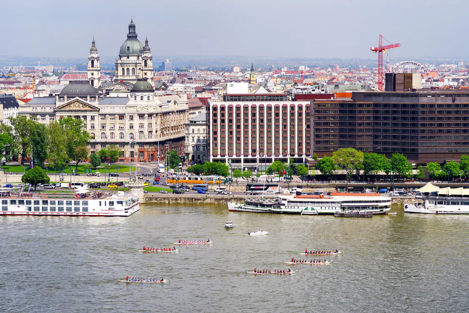 Kayakers paddling on Danube River with Budapest's historic waterfront and St. Stephen's Basilica in background